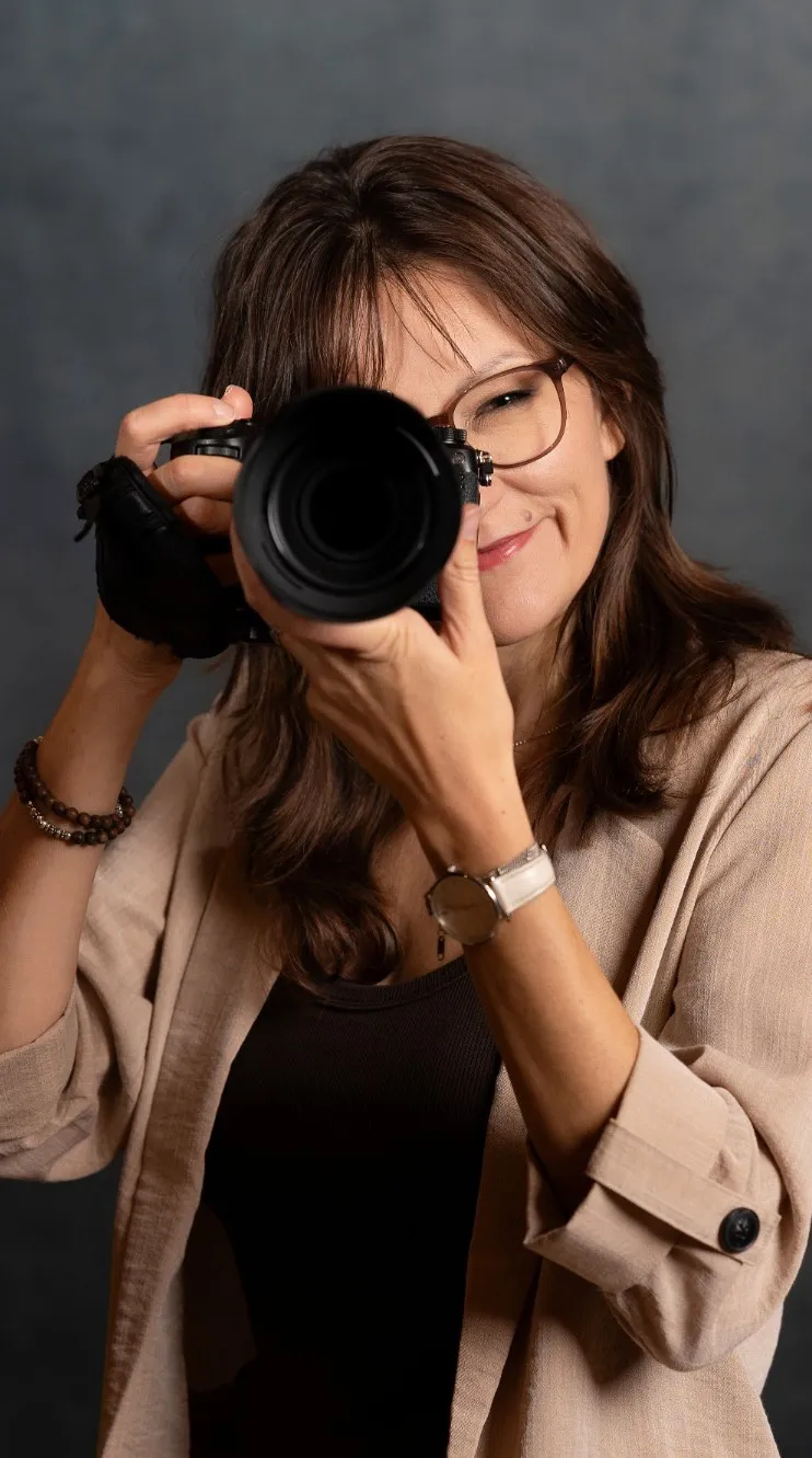 Seraina Wild mit Brille hält die Kamera vors Gesicht und lächelt
