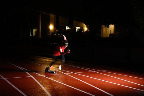 Leerer Sportplatz mit Rasen und Linien, im Hintergrund die Raenge