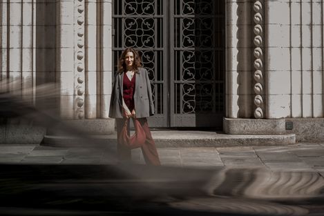 Frau geht vor einer Altstadtfassade, im Vordergrund verwischte Bewegung