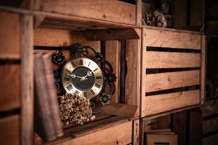 Antike Uhr und getrocknete Blüten in einer alten Holzkiste