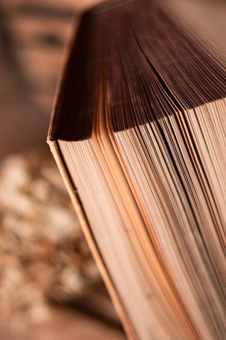 Aufgeschlagenes Buch, zu einem Lampenschirm gefaltet, warm beleuchtet