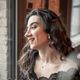 Porträt von Simona am Fenster, im Profil, lächelnd